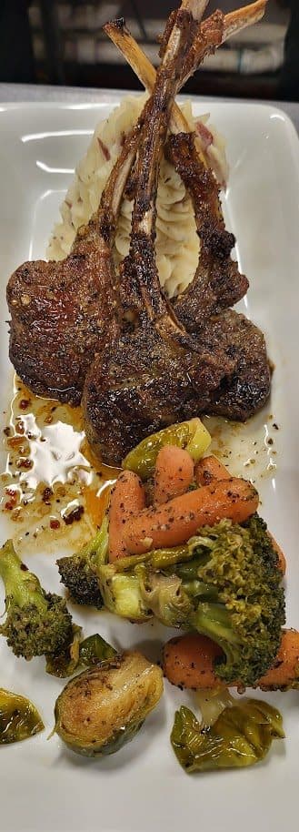 Braised lamb shank plated with roasted vegetables